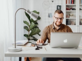 A person using project management software on a Macbook.