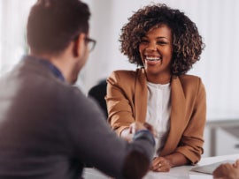 Happy businesswoman shaking hands with colleage after successful meeting.